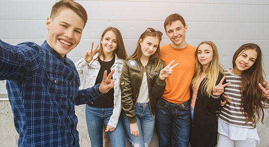 Junge Menschen lachen und machen ein Selfie.